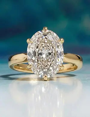 Gold solitaire engagement ring featuring a sparkling oval-cut diamond