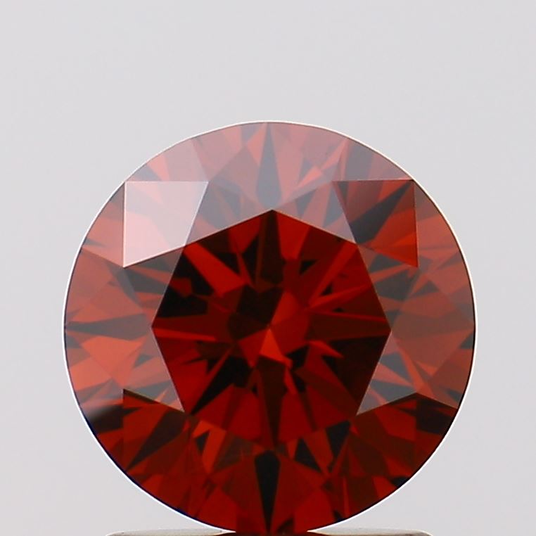 1.5 A round, faceted red gemstone with a deep hue, possibly garnet or ruby.