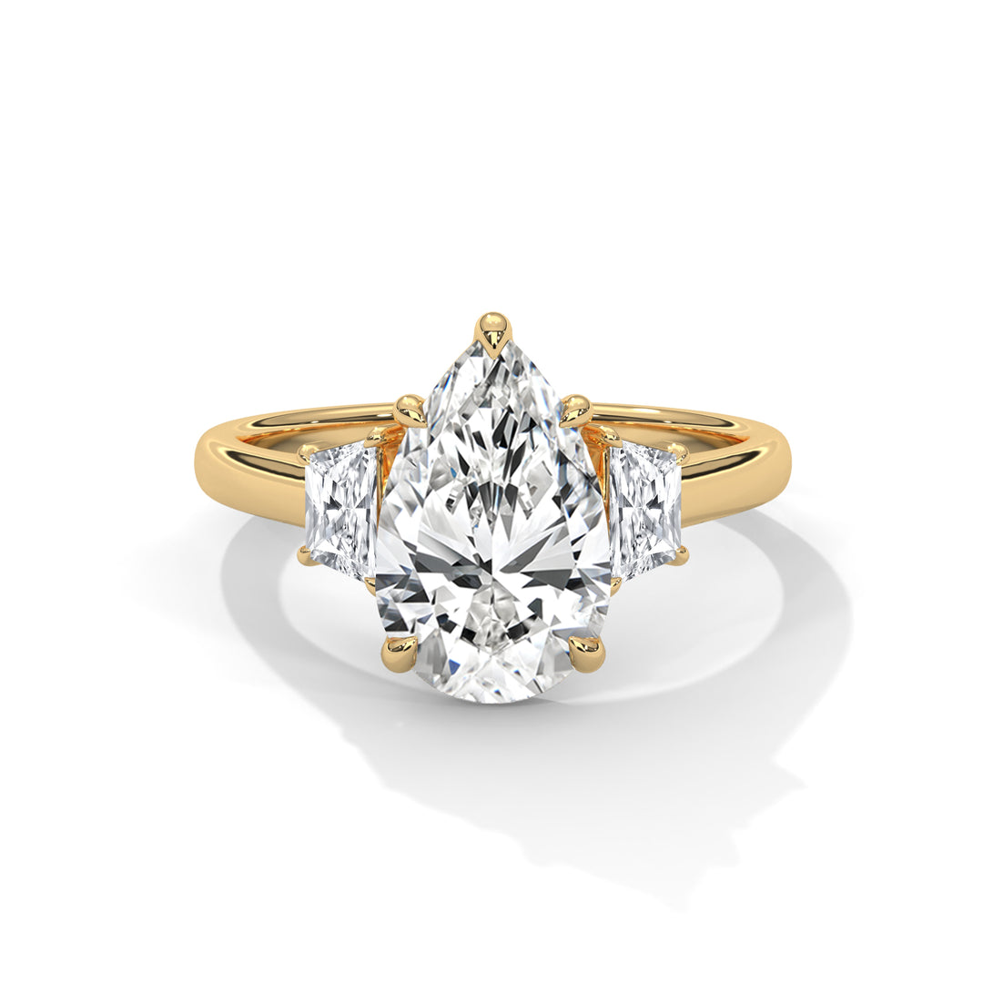 Gold ring with a pear-shaped diamond on a white background