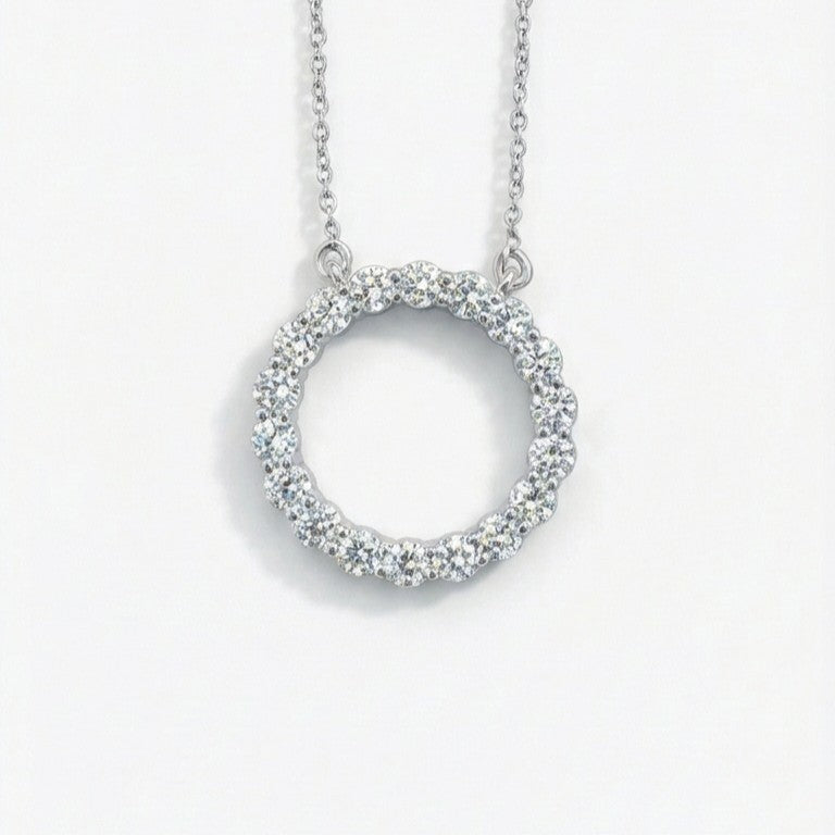 Silver necklace with a circular pendant on a white background