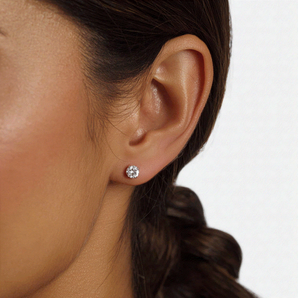 Lab-grown diamond round four-prong stud earring in 14k white gold worn on ear