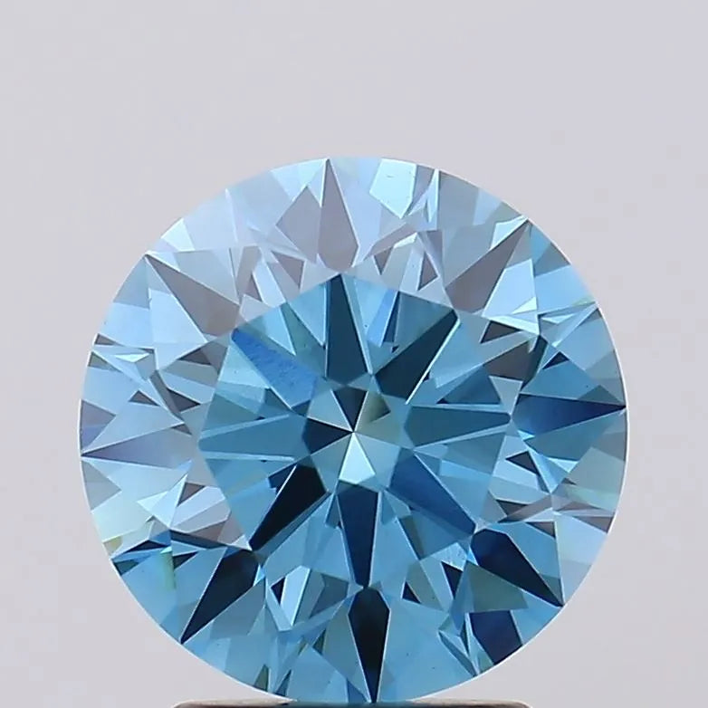 2.73 A round cut faceted blue gemstone with a light background.
