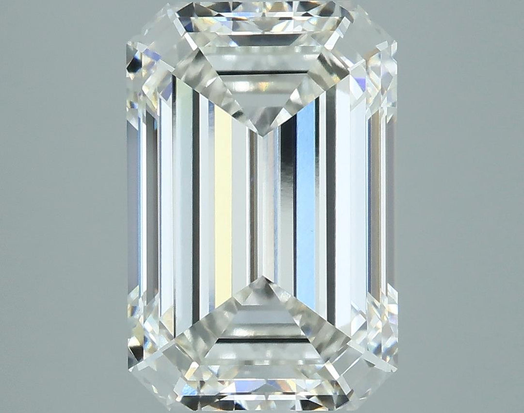 3.52 A clear emerald-cut diamond with intricate facets reflecting light, showcasing its brilliance and clarity against a gray background.