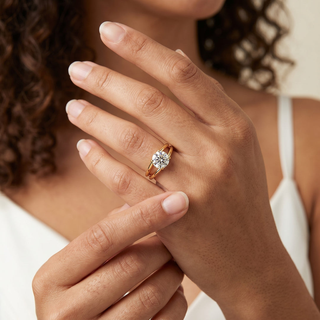 A woman gently touches her finger, displaying a gold engagement ring with a large diamond