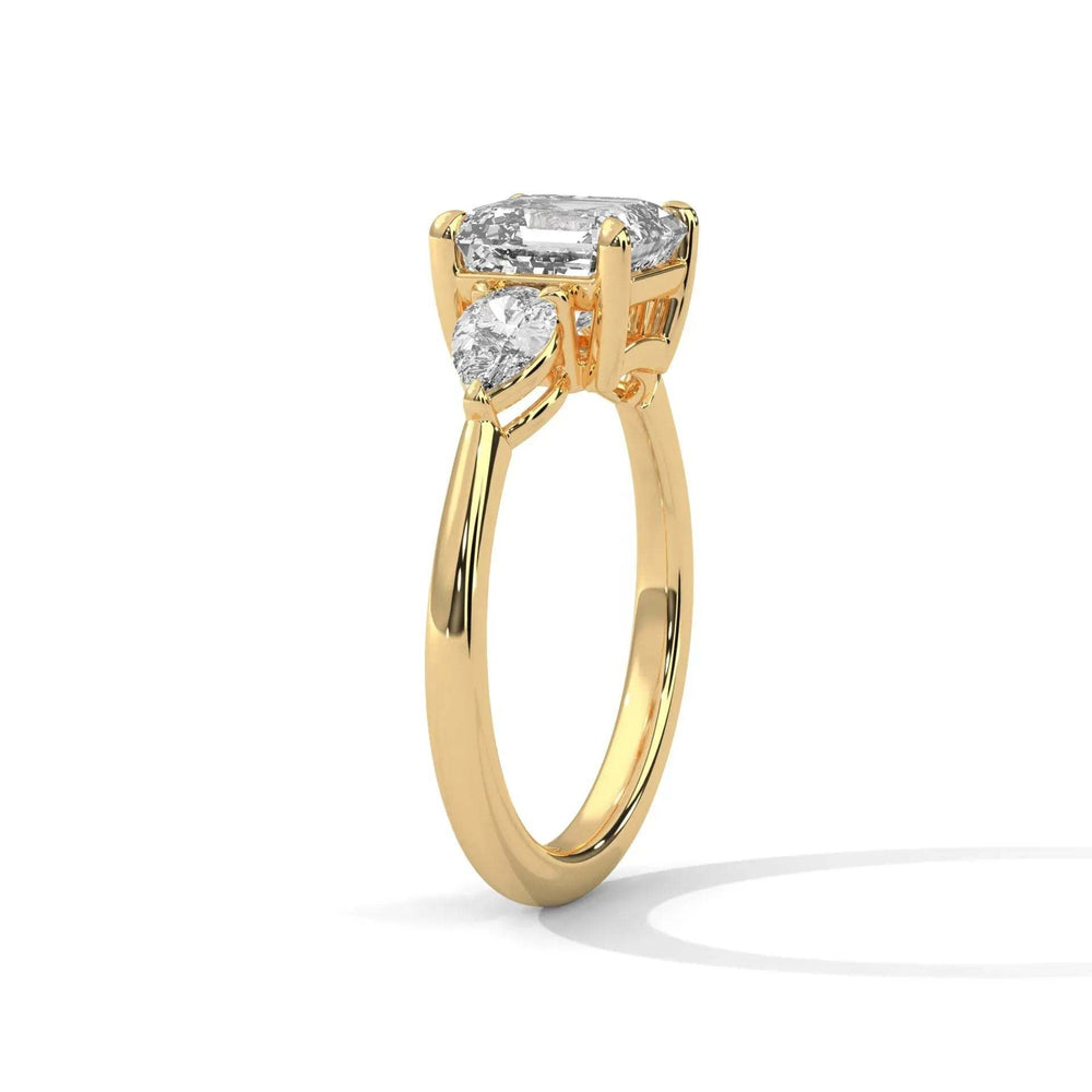 Three Stone Nova Diamond Ring Setting with central emerald-cut diamond and two pear-shaped side diamonds in yellow gold band