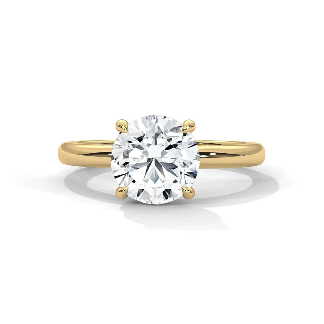 Classic Solitaire Setting engagement ring with a round diamond in a 14k yellow gold minimalist band handcrafted in New York City