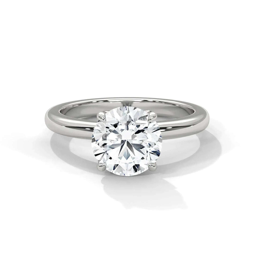 A close-up of a solitaire engagement ring with a large, round diamond set on a sleek silver band. The diamond sparkles, conveying elegance and luxury.