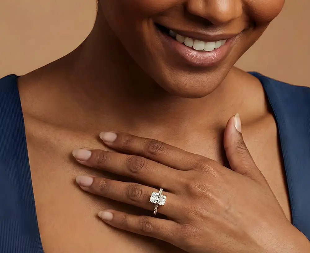 Lifestyle close-up of a woman wearing a cushion-cut diamond engagement ring on her hand while smiling