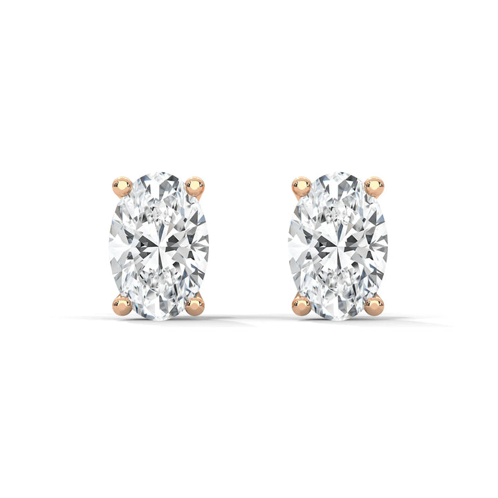 A pair of oval cut diamond stud earrings with rose gold settings on a white background.