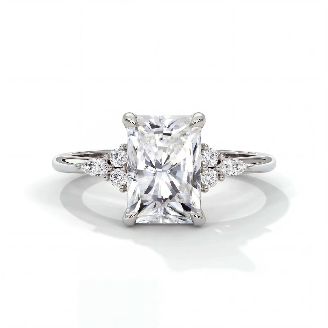 Elegant engagement ring with a radiant-cut diamond center stone and smaller round diamonds on each side, set in a simple platinum band.
