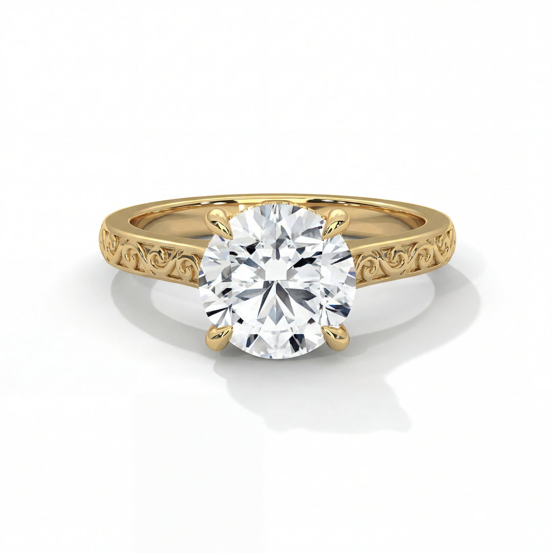 Elegant gold engagement ring with a large, round diamond in a prong setting. The band features intricate, swirling engravings, conveying a classic, luxurious feel.
