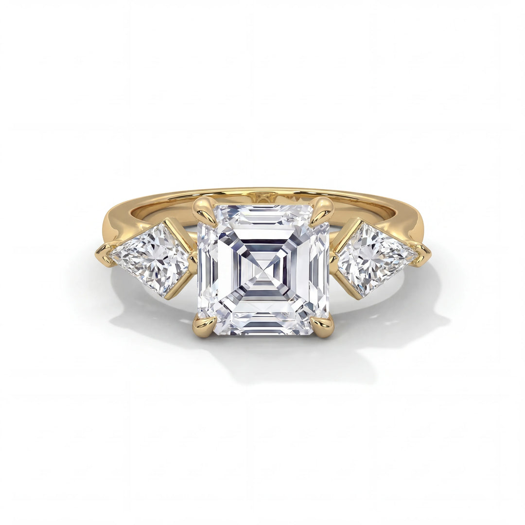 Elegant gold ring featuring a central square-cut diamond flanked by two triangular diamonds, showcasing luxury and sophistication on a white background.