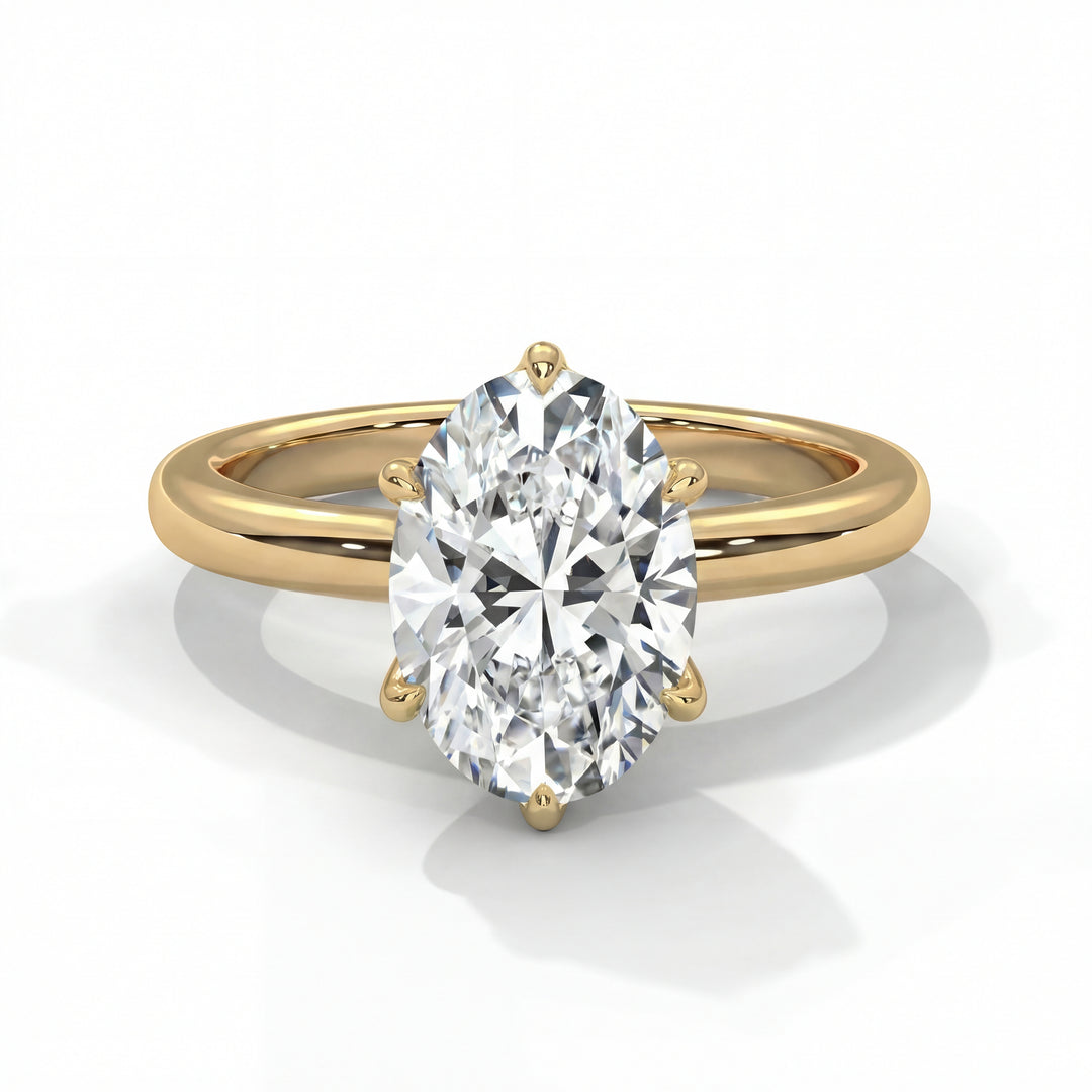 An elegant gold ring showcases an oval-cut diamond, sparkling with brilliance. The ring exudes luxury and sophistication against a soft white background.