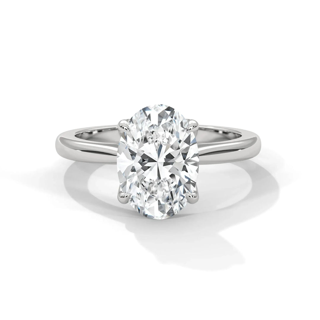 Elegant oval-cut diamond ring with a sleek white gold band. The sparkling diamond is set with four prongs, conveying a sense of timeless sophistication.