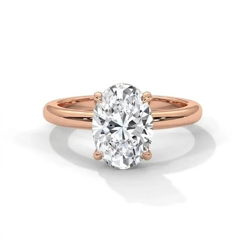 An elegant oval diamond engagement ring with a rose gold band, highlighting the sparkling gem's brilliance against a clean white background.