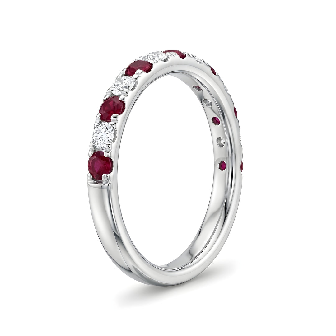 Elegant white gold ring adorned with alternating red rubies and sparkling diamonds, conveying a sense of luxury and sophistication.