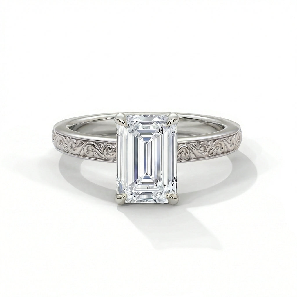 Emerald cut diamond solitaire engagement ring in 14k white gold with vintage inspired hand engraved scrollwork and milgrain detailing on the band
