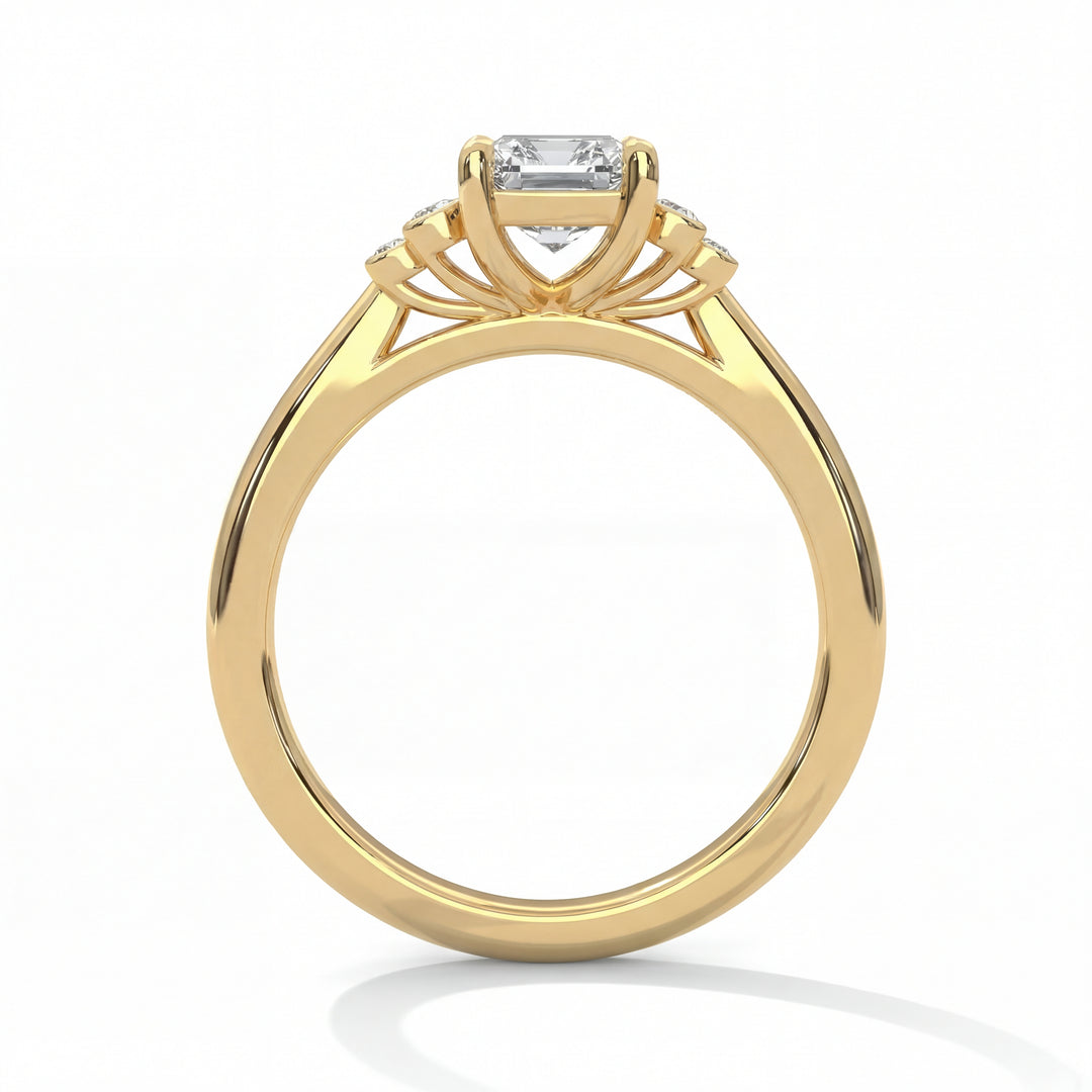 Side profile view of emerald cut diamond engagement ring in yellow gold with architectural openwork gallery and classic solitaire setting