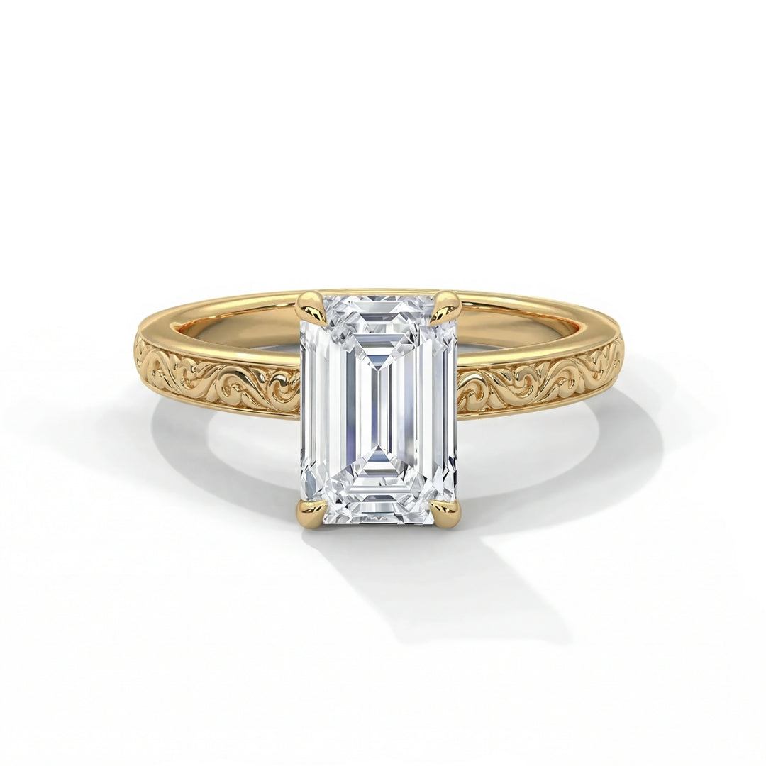 Emerald cut diamond solitaire engagement ring in 14k yellow gold with vintage inspired hand engraved scrollwork and milgrain detailing on the band