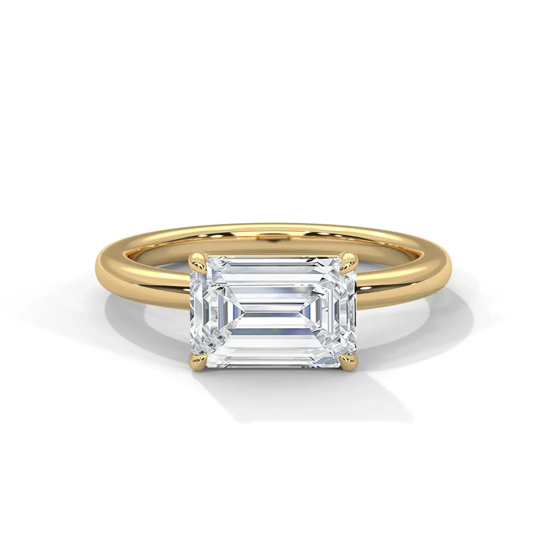 A gold band ring featuring a large, rectangular emerald-cut diamond in a prong setting, set against a plain white background, exuding elegance.