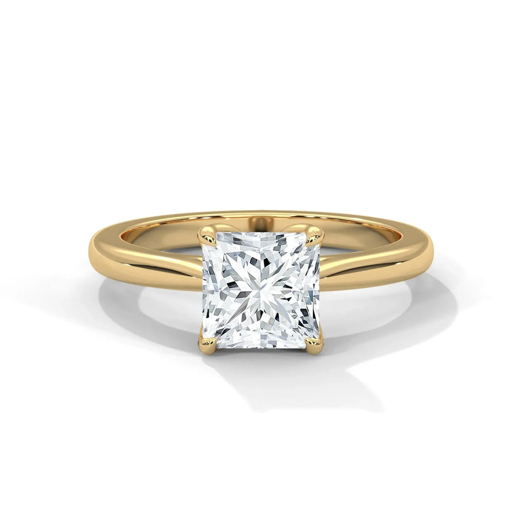 Gold engagement ring with a central square-cut diamond on a plain band, reflecting elegance and sophistication, set against a white background.