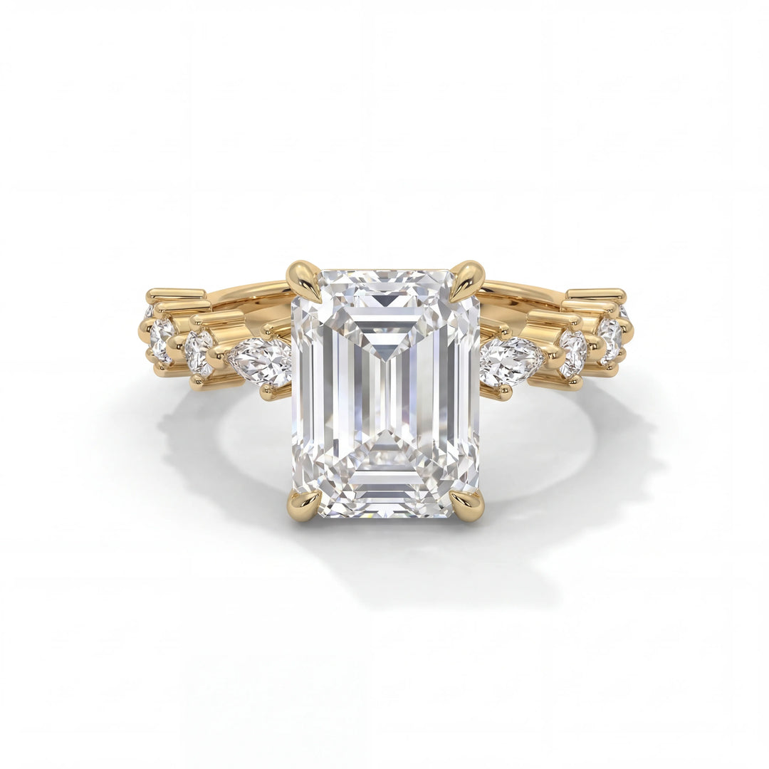 A gold engagement ring features a large emerald-cut diamond at the center, flanked by smaller round diamonds along the band, creating a luxurious, elegant look.