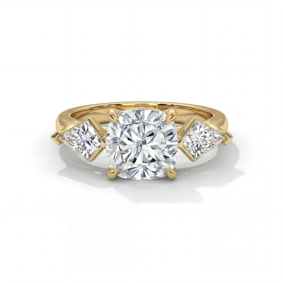 A gold engagement ring featuring a large cushion-cut center diamond flanked by two smaller square-cut diamonds on each side, showcasing elegance and luxury.