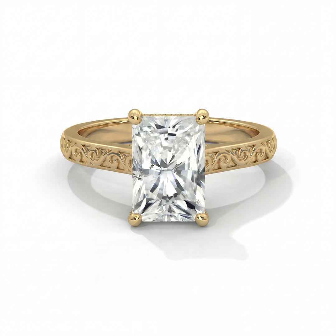A gold engagement ring with an intricate band design featuring a radiant-cut diamond in a four-prong setting, reflecting elegance and sophistication.