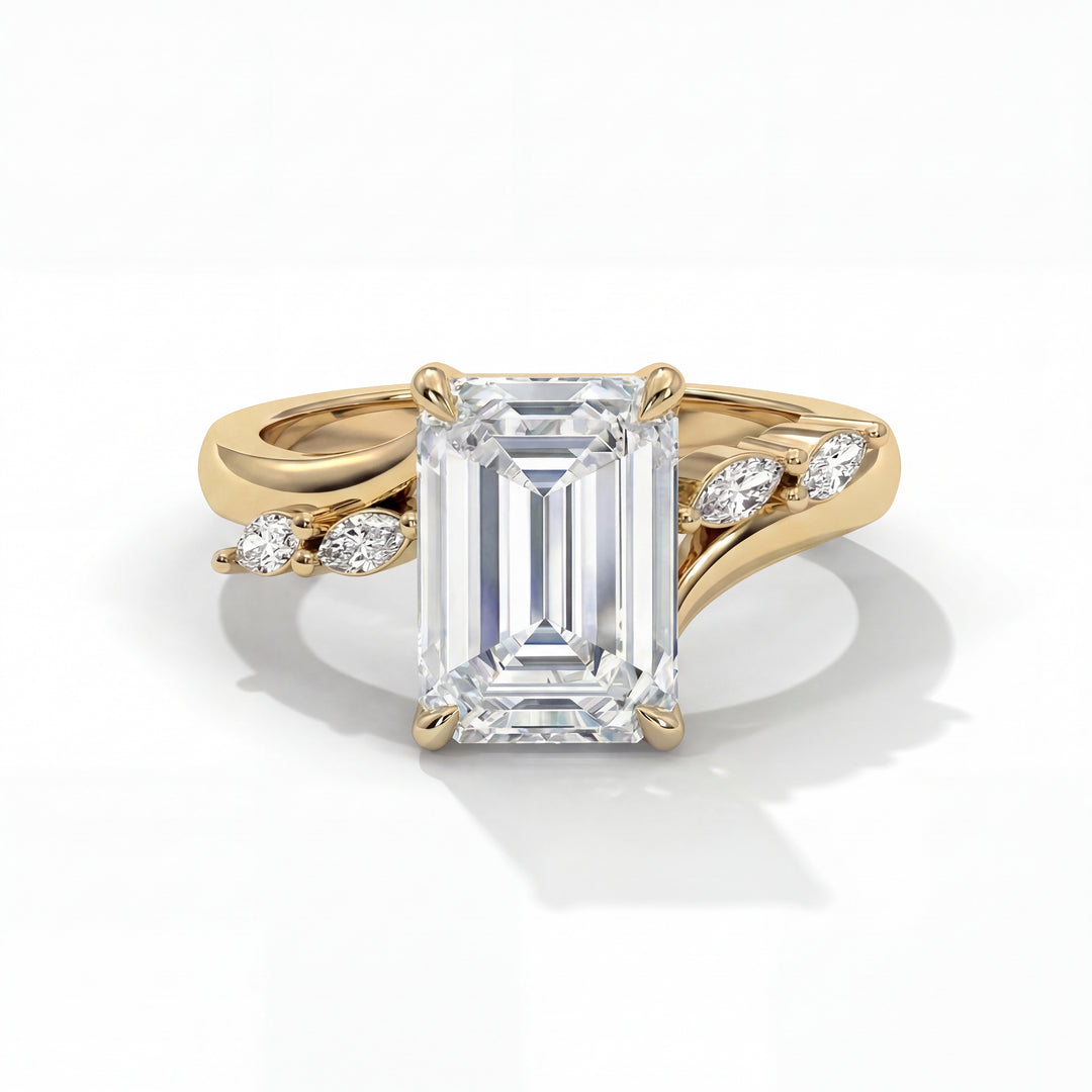 A gold engagement ring with a large emerald-cut diamond in the center, flanked by small marquise diamonds on each side, evoking elegance and luxury.