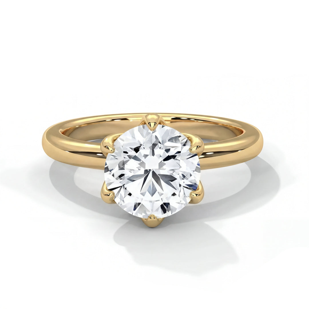 A gold engagement ring with a large, round-cut diamond centerpiece on a simple band. The diamond sparkles, conveying elegance and luxury.