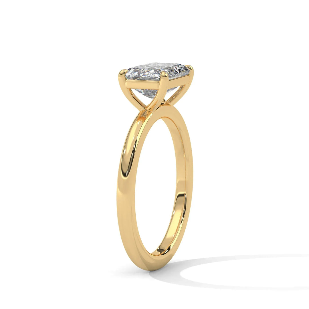 A gold engagement ring with a large, round diamond in a four-prong setting. The elegant design casts a soft shadow, exuding luxury and sophistication.