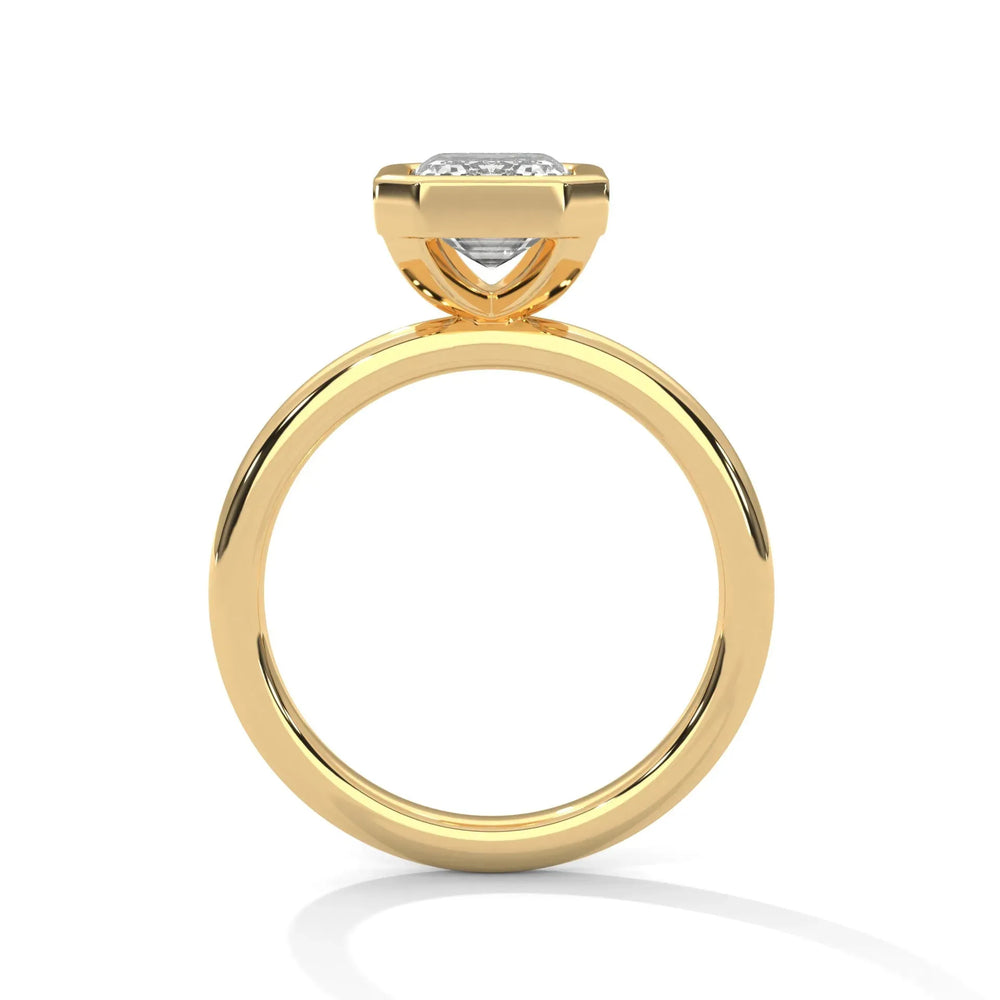 A gold engagement ring with a round diamond in a bezel setting. The sleek design and polished finish convey elegance and luxury.