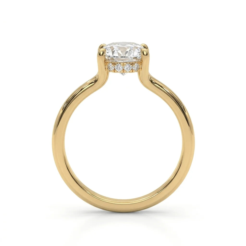 A gold engagement ring with a round diamond solitaire setting. The ring features a row of small diamonds below the main stone, exuding elegance and luxury.