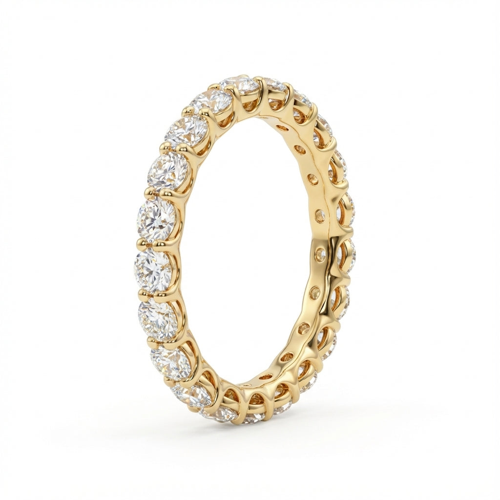 A gold eternity ring studded with round, sparkling diamonds encircles the entire band, set against a plain white background, conveying elegance and luxury.