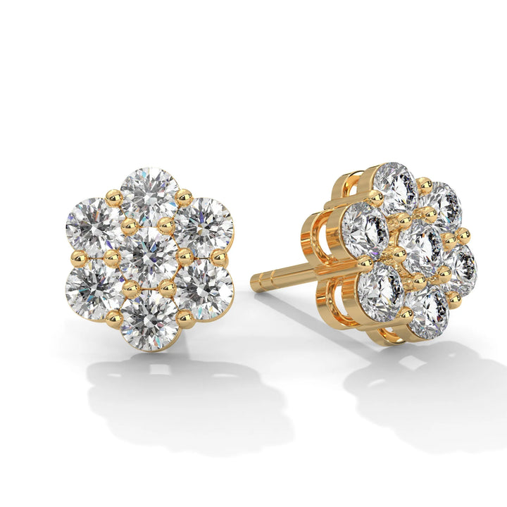 Gold flower-shaped earrings with multiple diamonds on a white background.