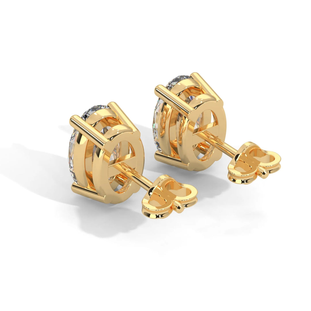 A pair of gold diamond stud earrings on a white background.