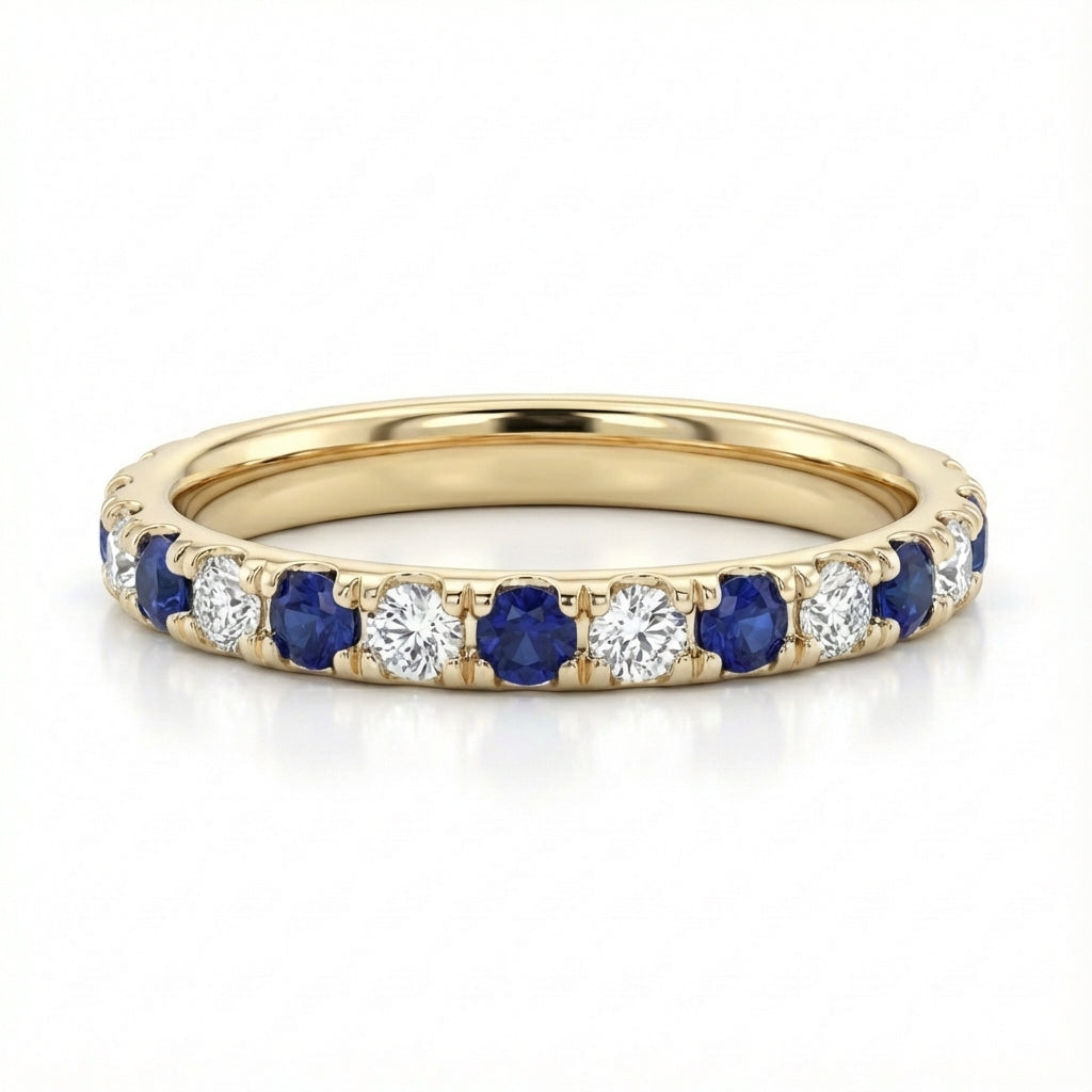Gold ring with alternating blue sapphires and white diamonds. The gemstones are set in a continuous pattern, giving a luxurious and elegant feel.
