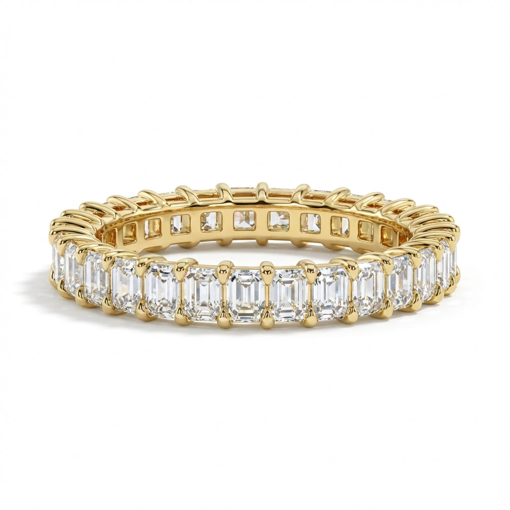 Gold ring with emerald-cut diamonds on a white background