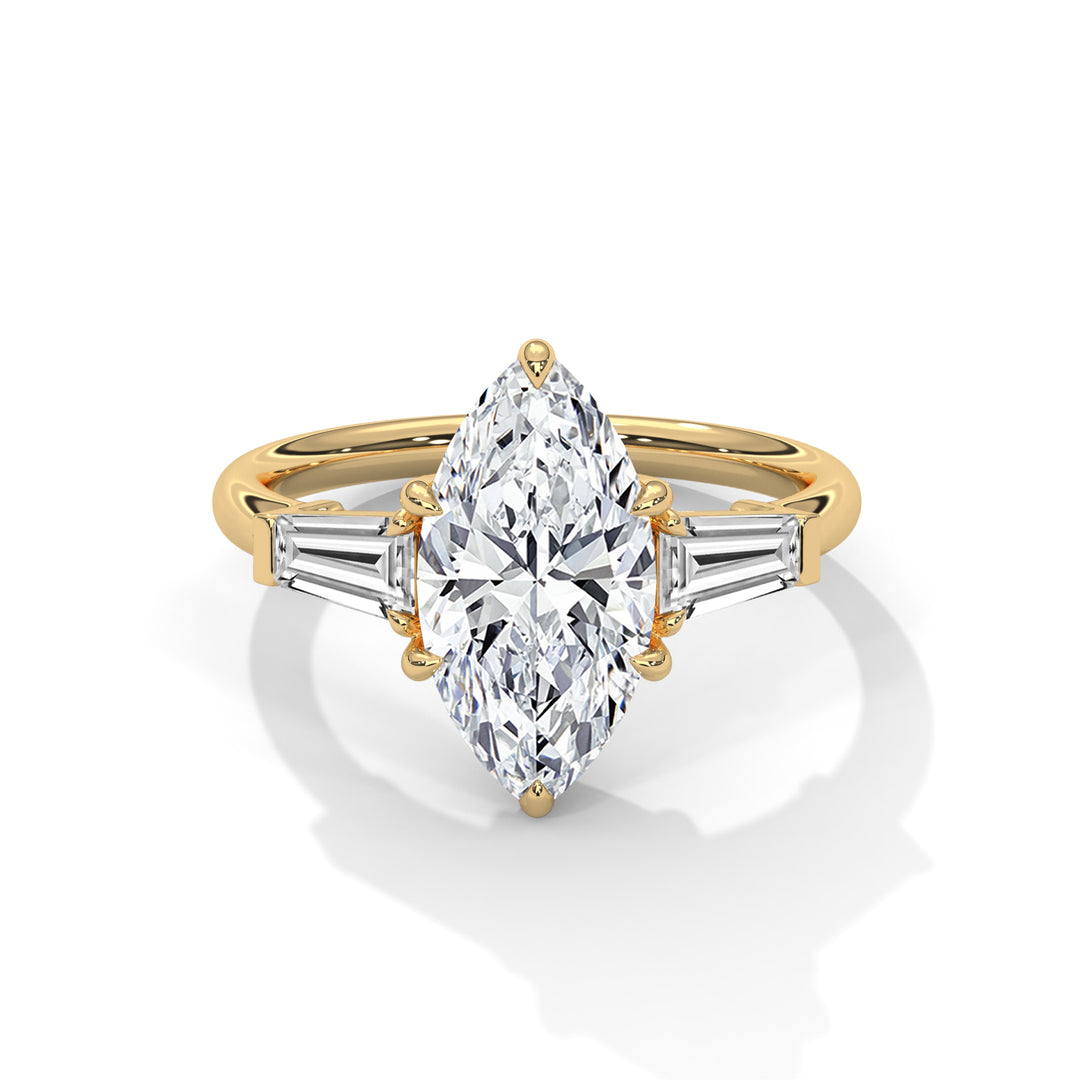 A gold ring featuring a large, marquise-cut diamond centerpiece is flanked by two slender baguette diamonds, exuding elegance and sophistication.