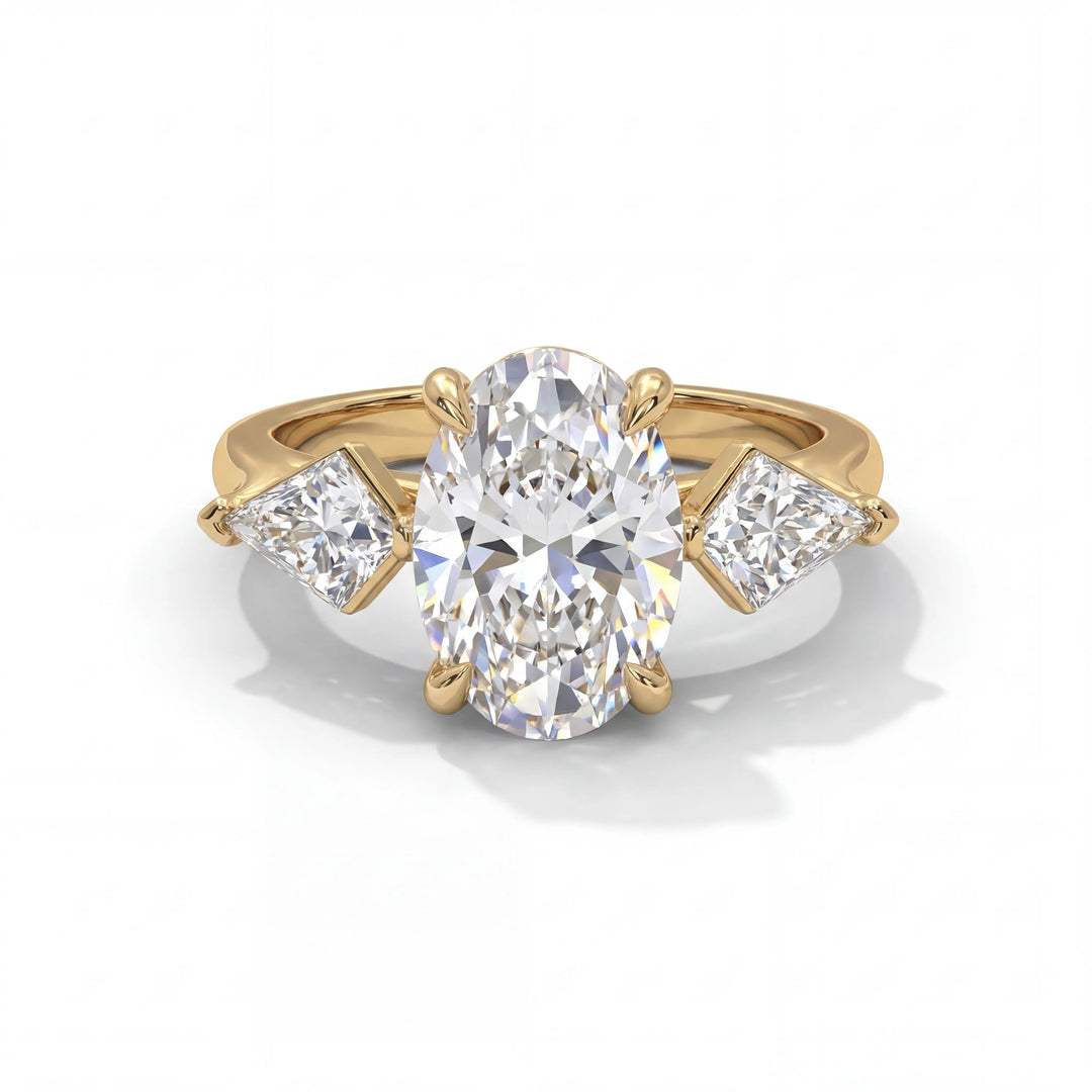 A gold ring featuring a large oval diamond centerpiece flanked by two smaller triangular diamonds. The design is elegant and luxurious.