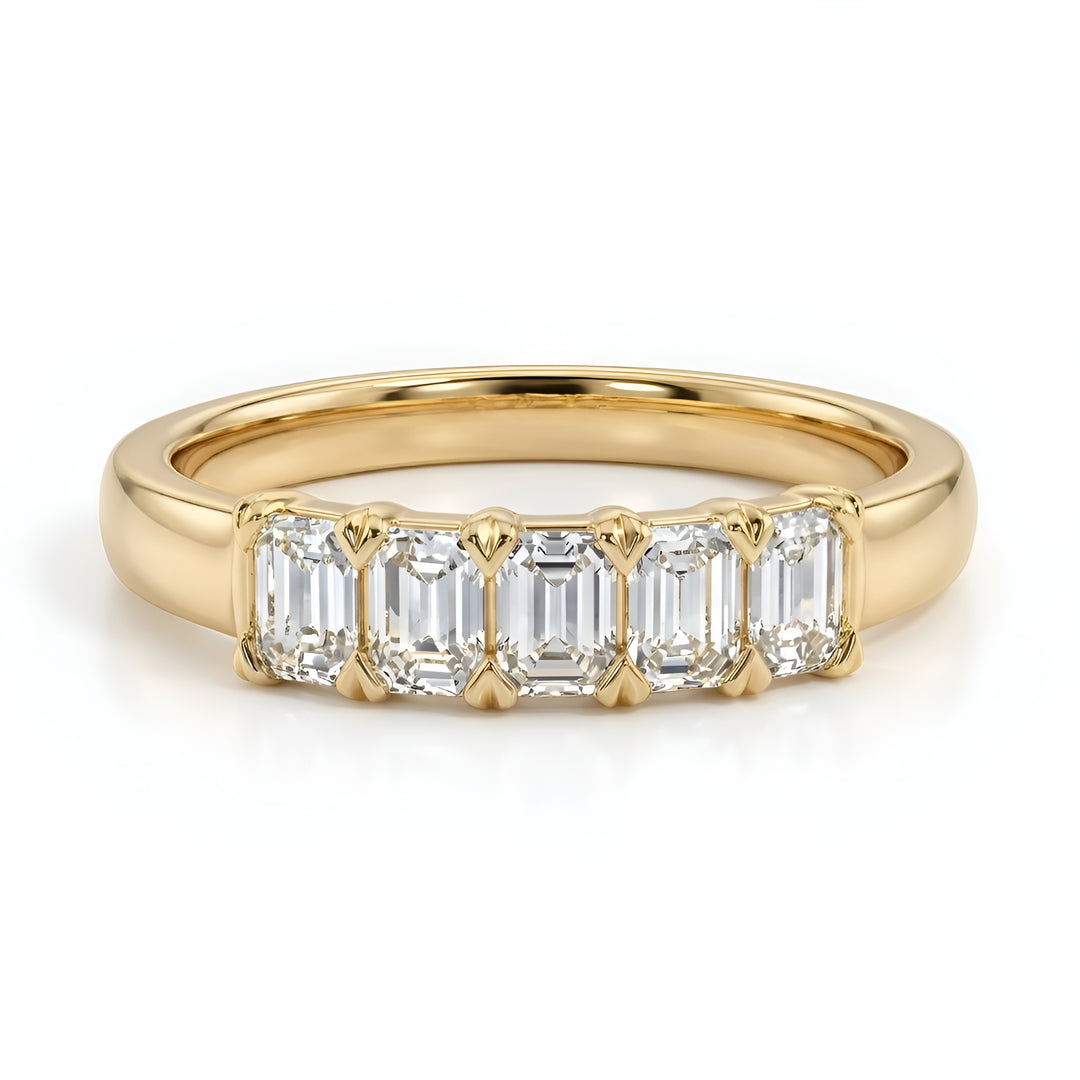 A gold ring with five emerald-cut diamonds set in a row, reflecting a luxurious and elegant design against a plain white background.