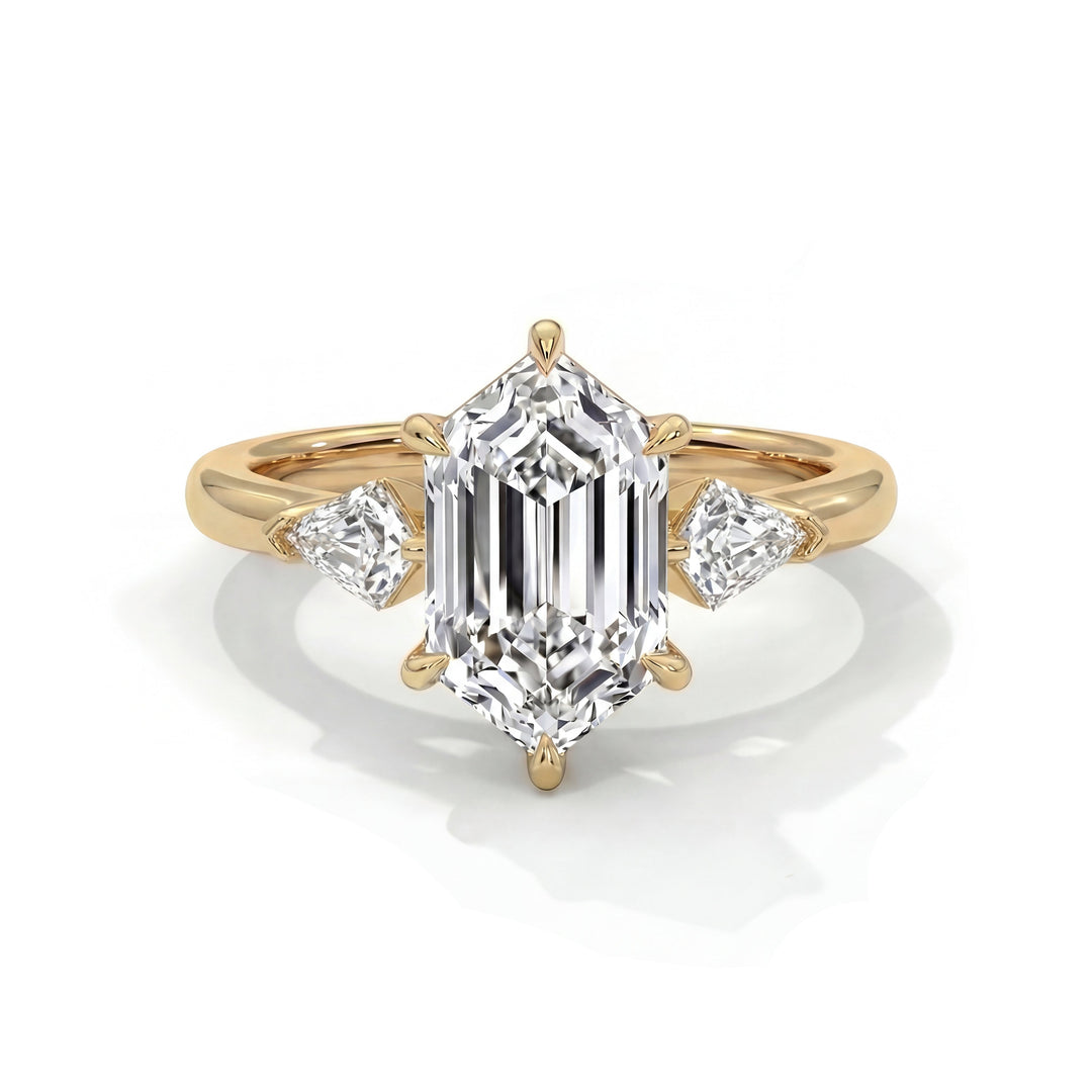 Gold ring with a large emerald-cut diamond centerpiece, flanked by two triangular diamonds. The setting is elegant and luxurious, reflecting sophistication.