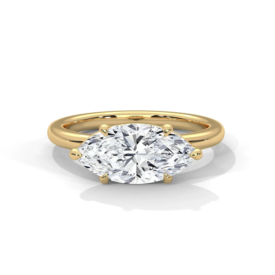 A gold ring with a large, marquise-cut diamond held by prongs, set against a white background. The elegant design exudes luxury and sophistication.