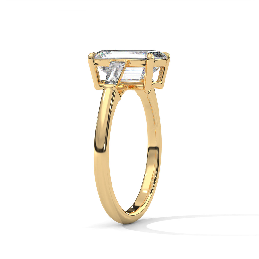 Gold ring with a large rectangular clear gemstone and smaller baguette-cut stones on the sides, shown against a white background.
