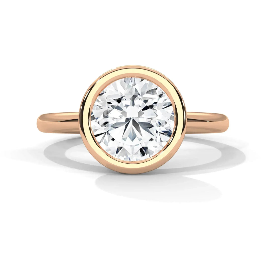 A gold ring with a large, round, dazzling diamond set in a bezel setting. The elegant and minimalist design conveys luxury and sophistication.