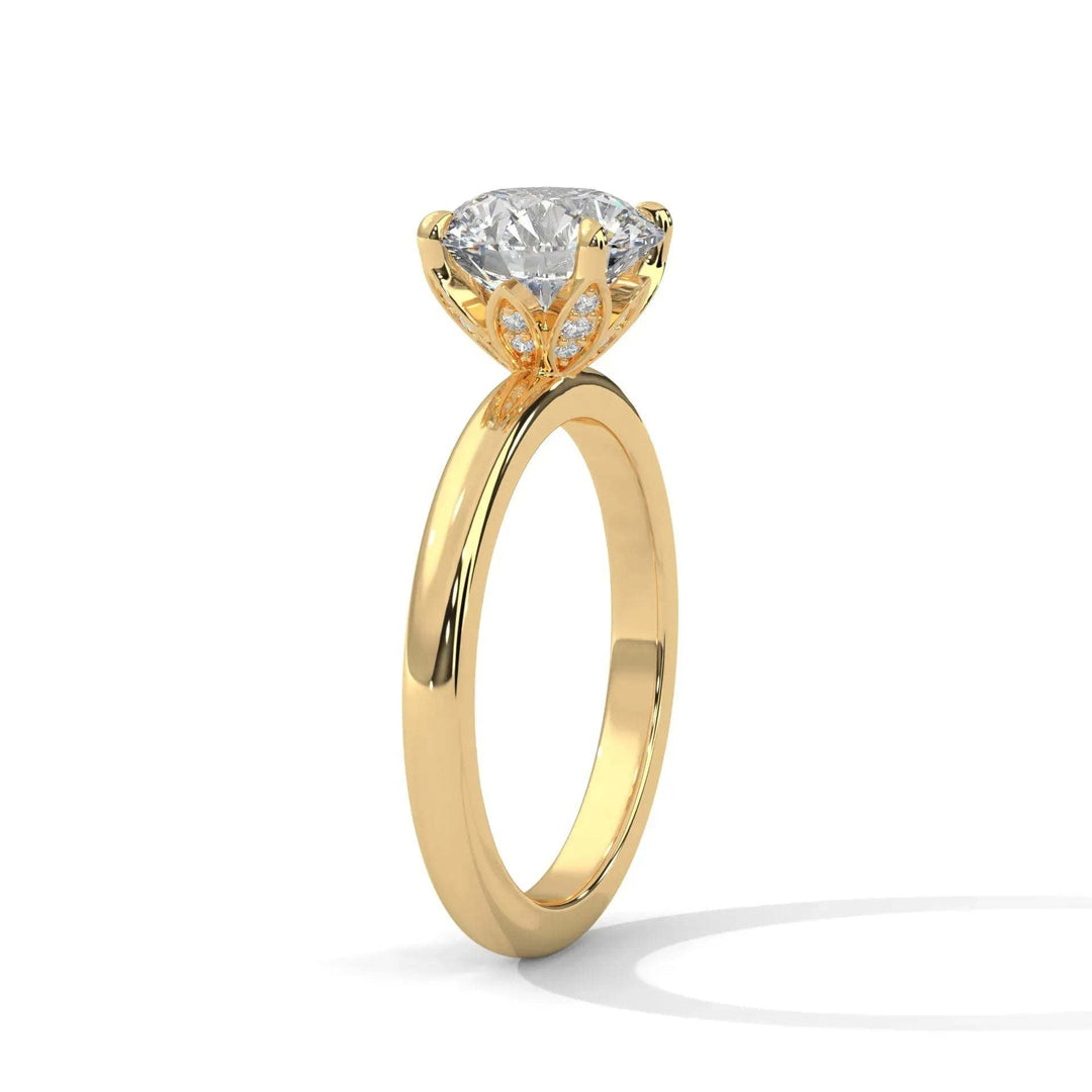Gold ring with a large, round diamond centerpiece held by an ornate butterfly-shaped setting. The design conveys elegance and sophistication.