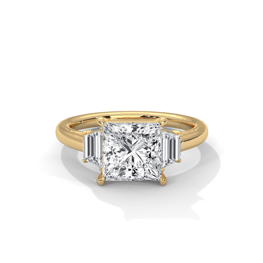 A gold ring with a large, square-cut diamond at the center flanked by two smaller baguette-cut diamonds. The ring exudes elegance and luxury.
