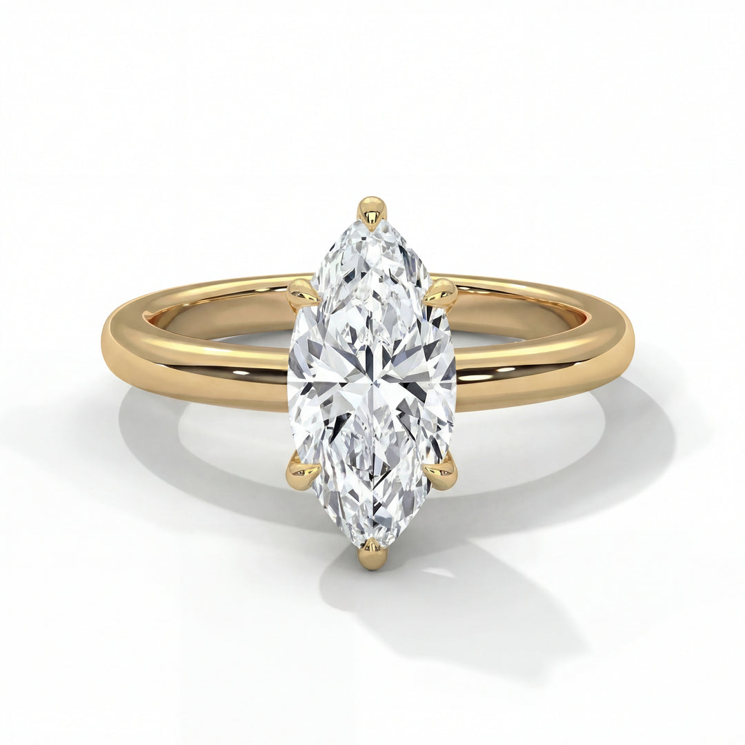 A gold ring with a marquise-cut diamond center stone, elegantly displayed on a reflective surface. The ring exudes a sense of luxury and sophistication.