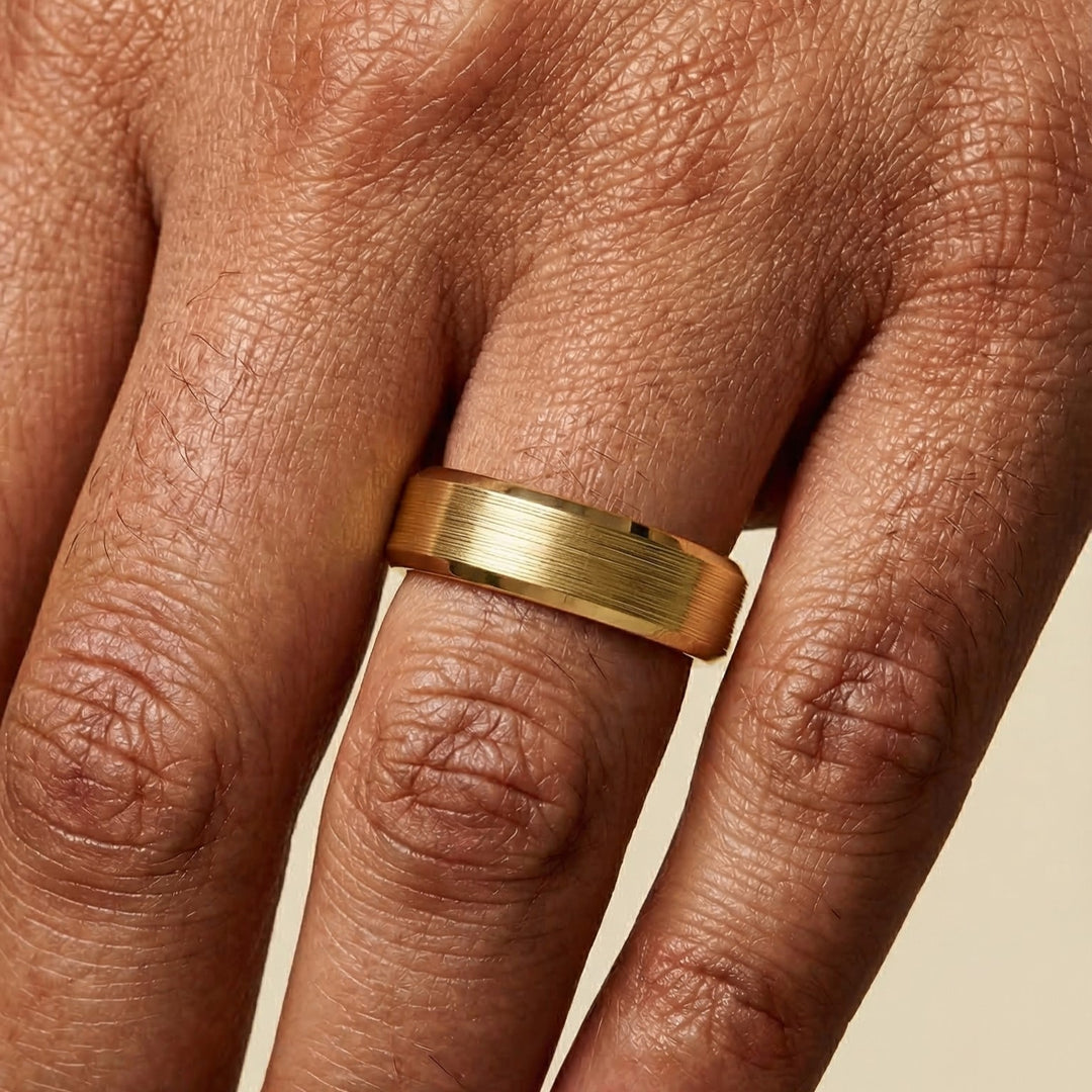 Gold ring on a person's finger with a beige background