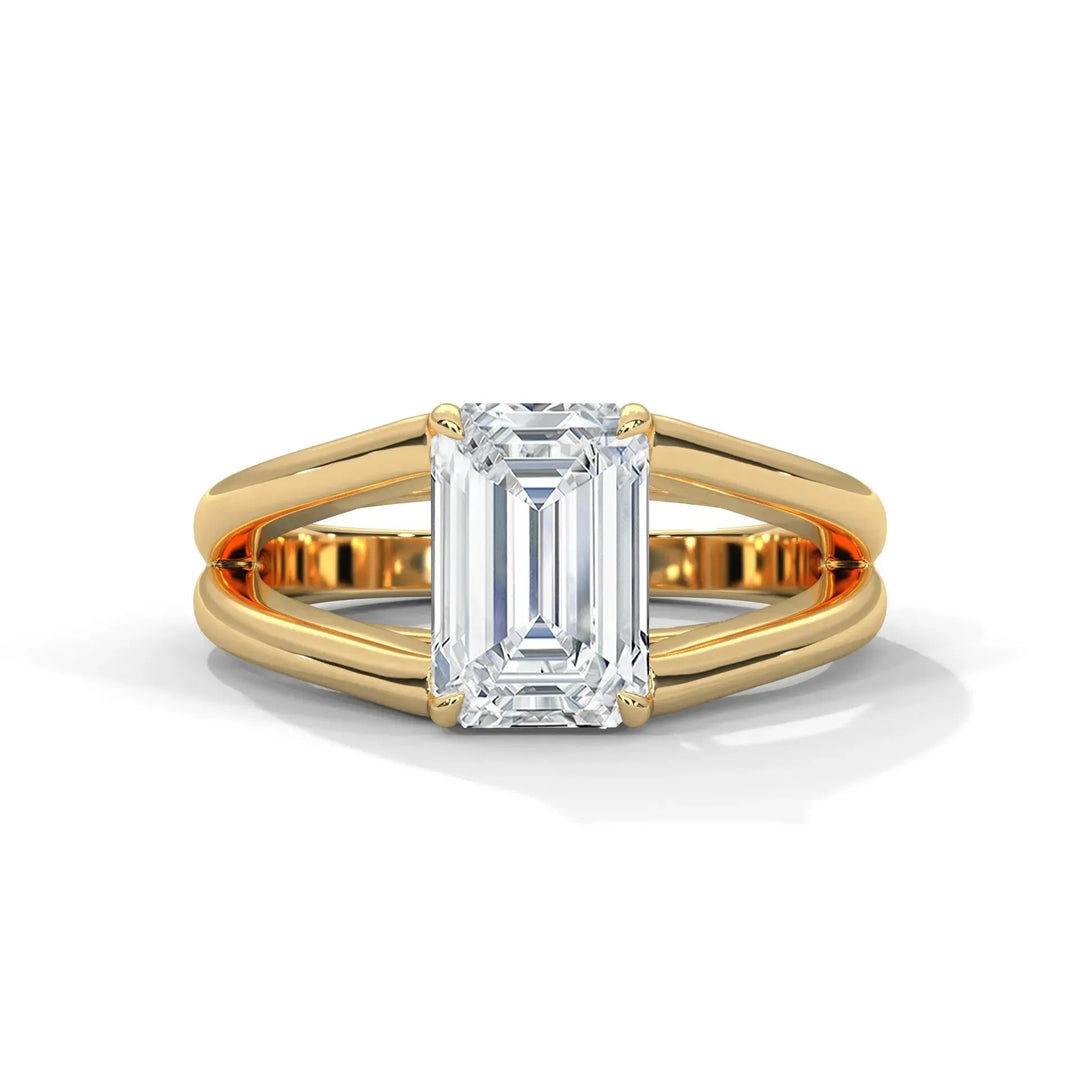 A gold ring with a rectangular, emerald-cut diamond set in a split shank band, reflecting elegance and luxury against a white background.